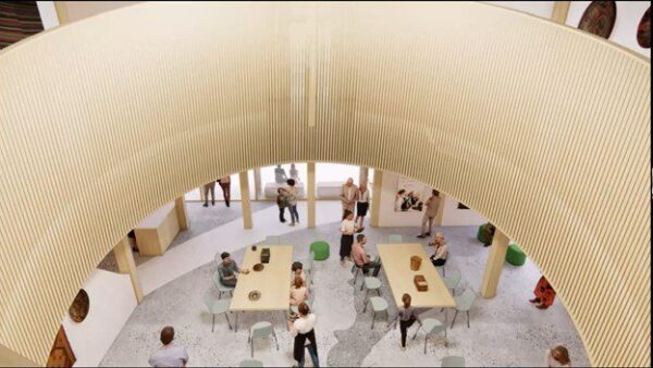 People are gathered around tables in a spacious, modern interior with curved wooden architecture and large windows.
